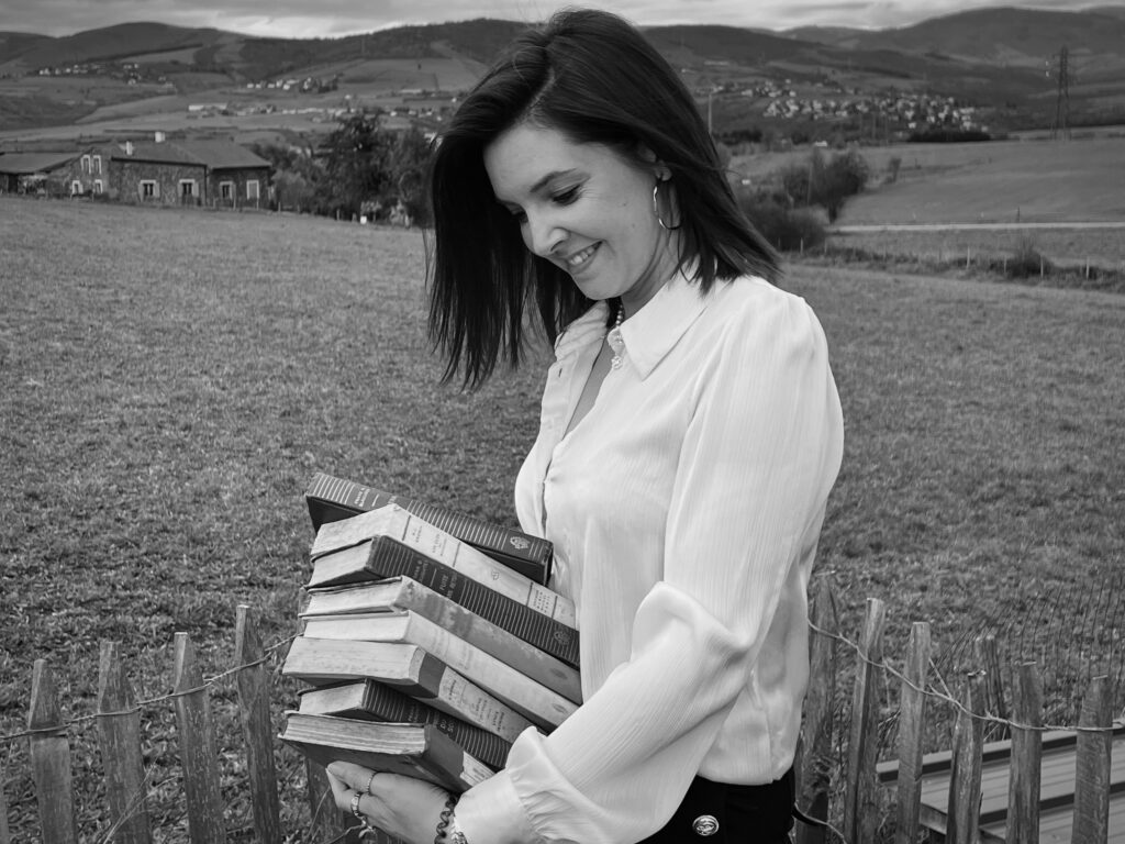 Une biographe tenant des livres anciens entre ses bras