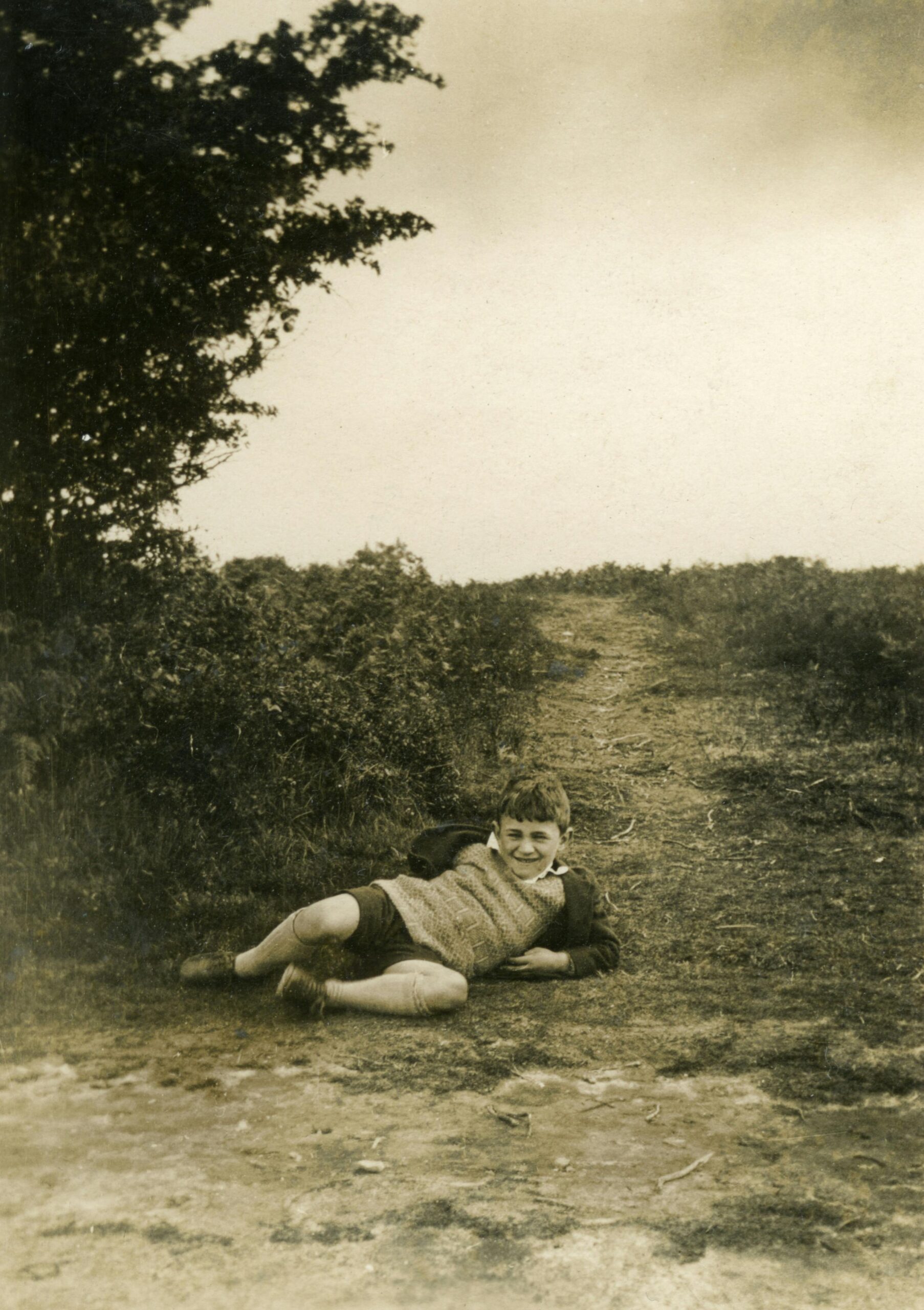 un enfant couché sur un chemin de terre dans les années 1930